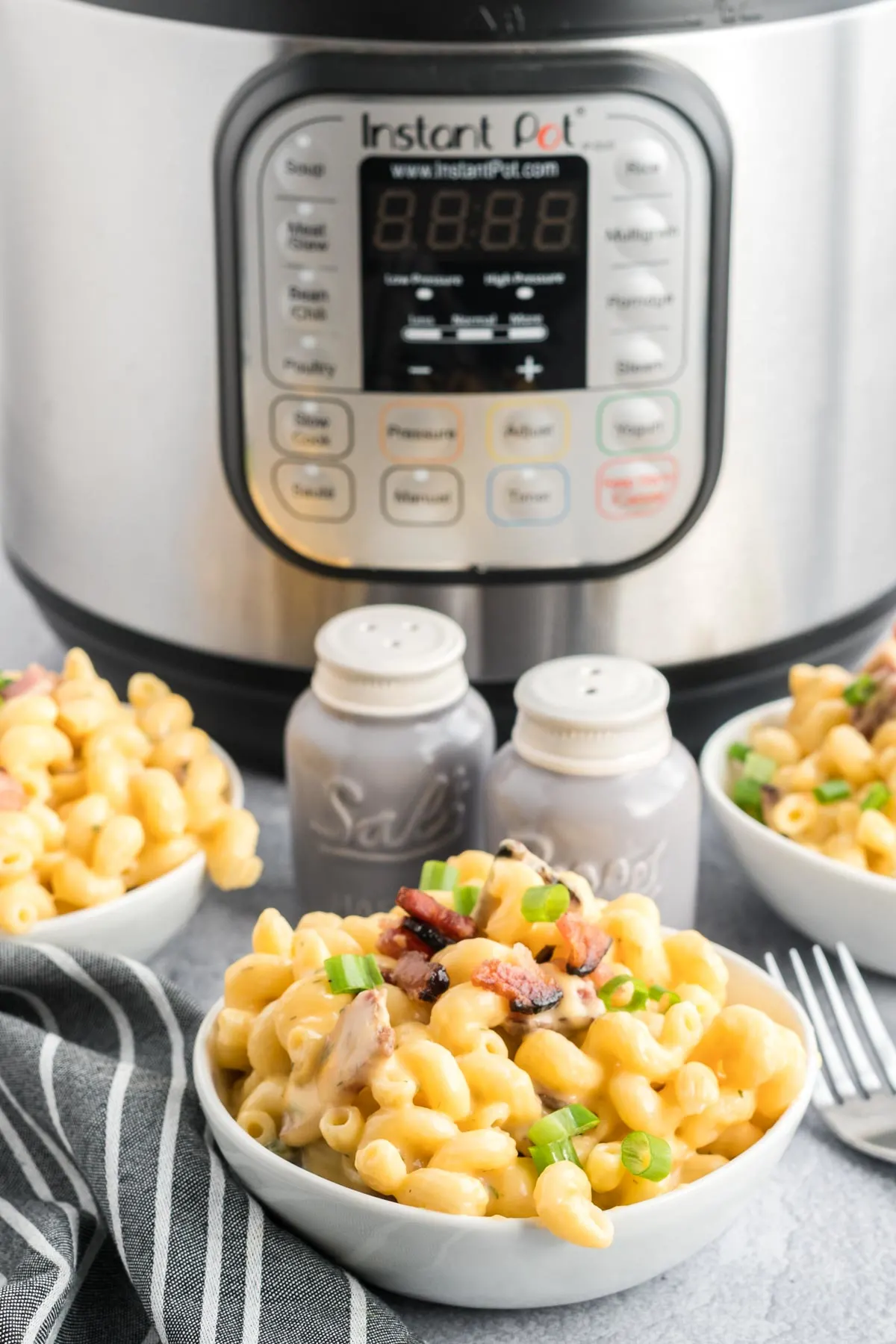 Mac and cheese in a bowl with an instant pot in the background.