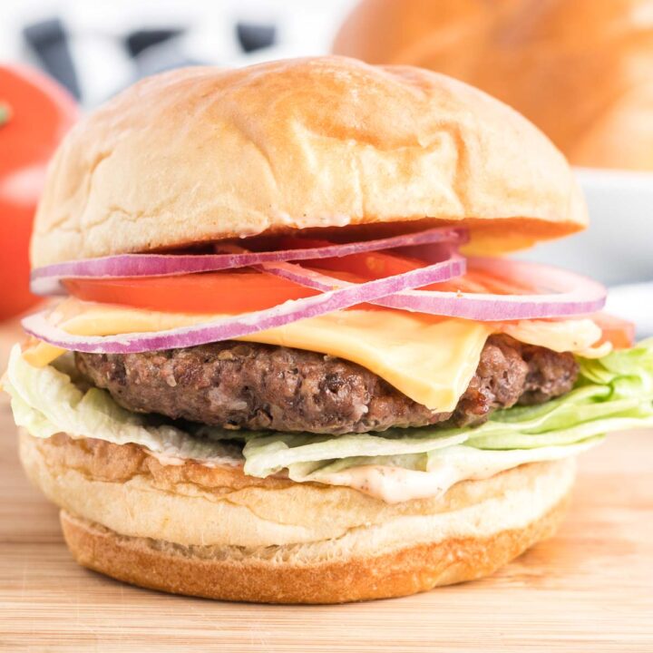 Beef burger on brioche bun topped with lettuce, tomato and onion.