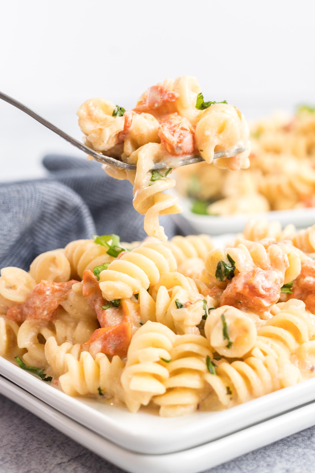 A serving of tomato feta pasta with a bite on a fork. 