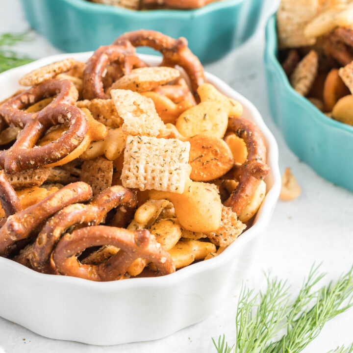 Snack mix of pretzels, crackers, peanuts and cereal in a bowl.