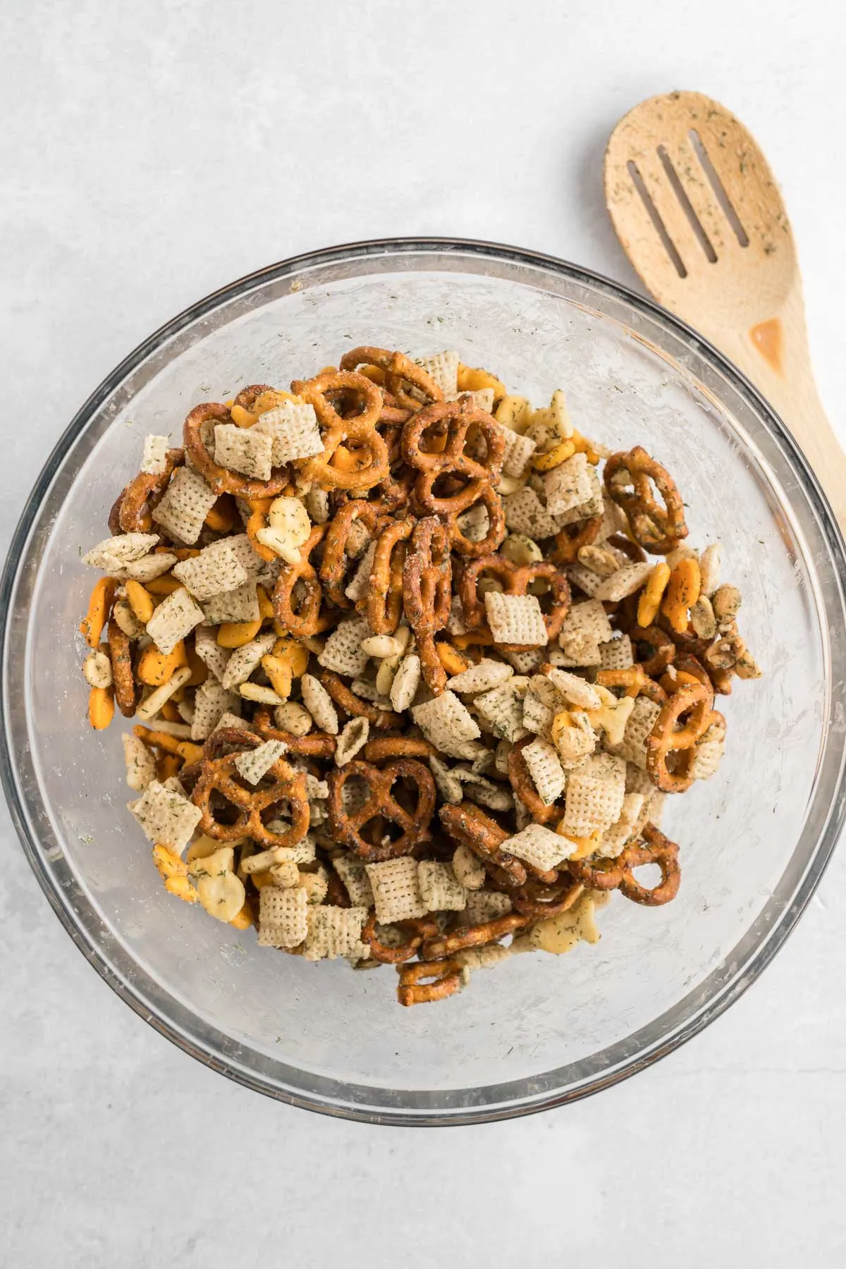 Chex mix, coated in seasoning and mixed in a mixing bowl. 