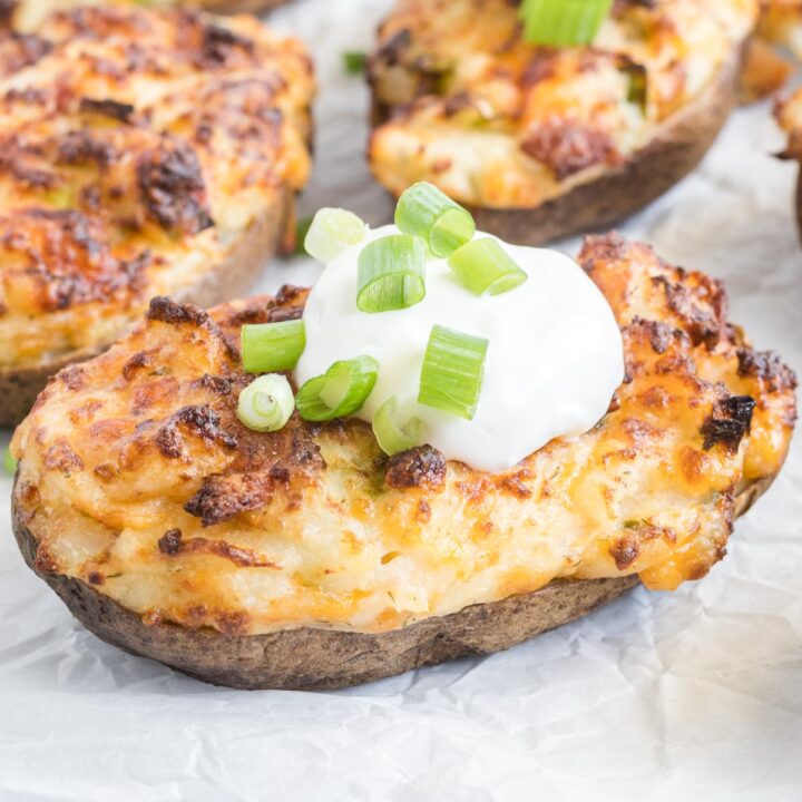 Stuffed baked potato topped with sour cream and green onion.