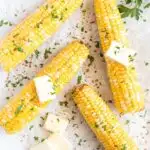 4 corn on the cobs with butter pats, salt and fresh chopped herbs.