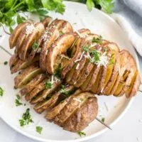 Crispy twisted potato skewers on a plate.