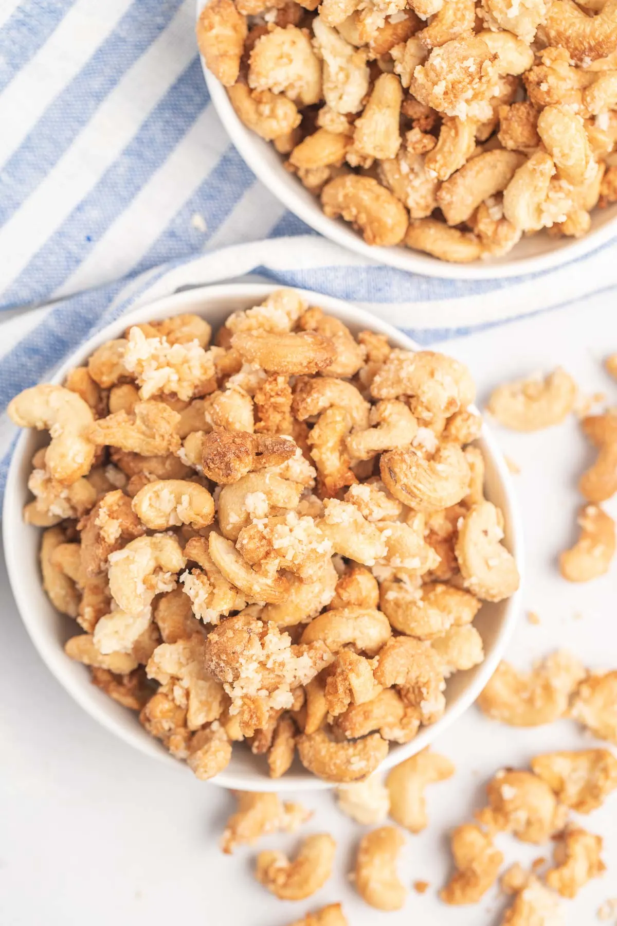 Coconut cashews in small white bowls.