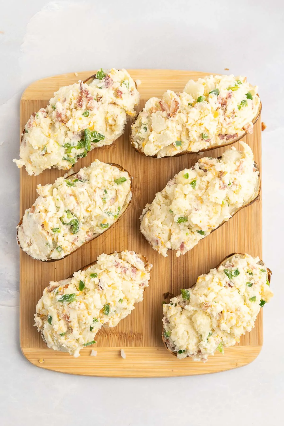 Six potato halves stuffed with mashed potato filling.