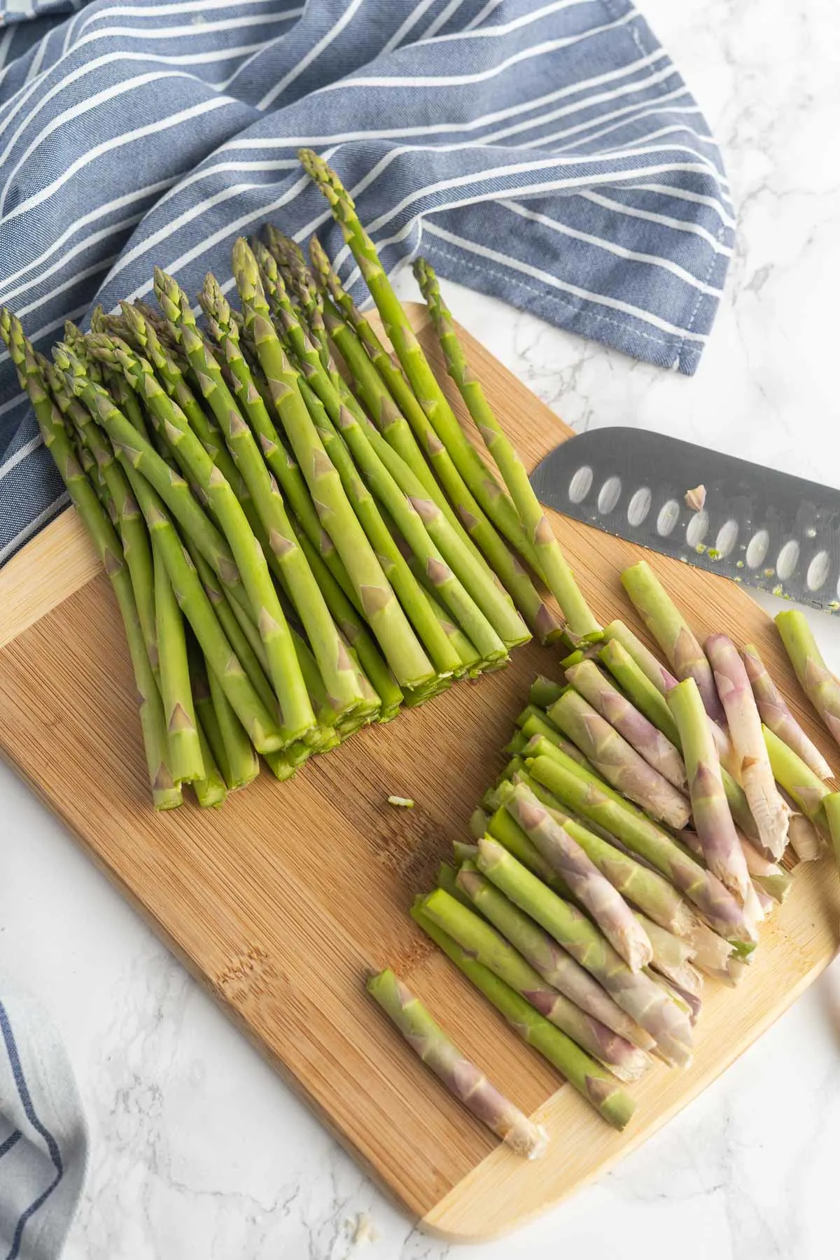 Asparagus on a cutting board with ends trimmed.