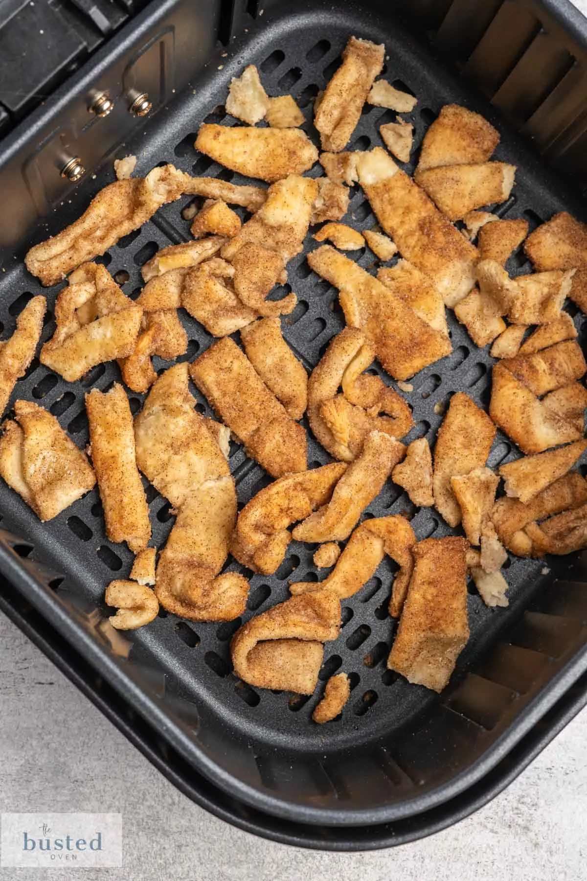 Crispy cinnamon sugar pastry in an air fryer basket.