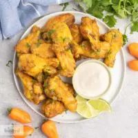 A plate of habanero hot wings with a dish of blue cheese dip.